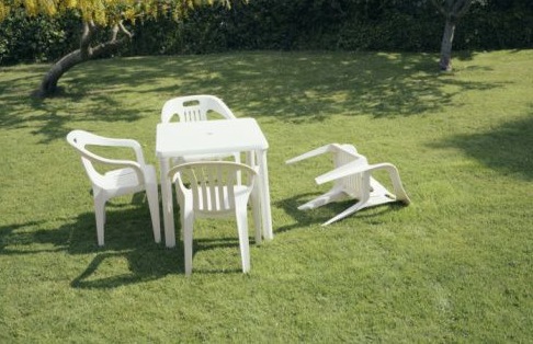Picture depicts a patio set with one chair knocked over